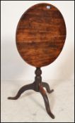 An 19th century mahogany tilt top wine / occasional table being raised on splayed tripod leg base