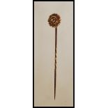 A 15ct gold Victorian stick pin, the head with roundel form having filigree work surrounding a