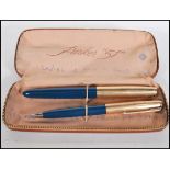 A Parker '51' pen and mechanical pencil having blue shafts with gold plated lids, within a fitted