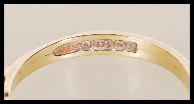 A hallmarked 9ct gold ring set with a square cut blue stone flanked by two round cut white stones. - Image 5 of 5