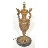 A large 20th Century twin handled gilt metal table lamp of urn shape form having pictorial relief