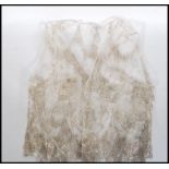 An early 20th Century Edwardian ladies lace waistcoat of small proportions, having silver woven