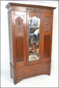 An early 20th Century 1920's single oak wardrobe having a central bevelled mirror door with panels