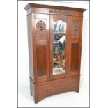 An early 20th Century 1920's single oak wardrobe having a central bevelled mirror door with panels