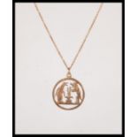 A stamped 9ct gold necklace having a round pendant having pierced decoration in the form of a dog,