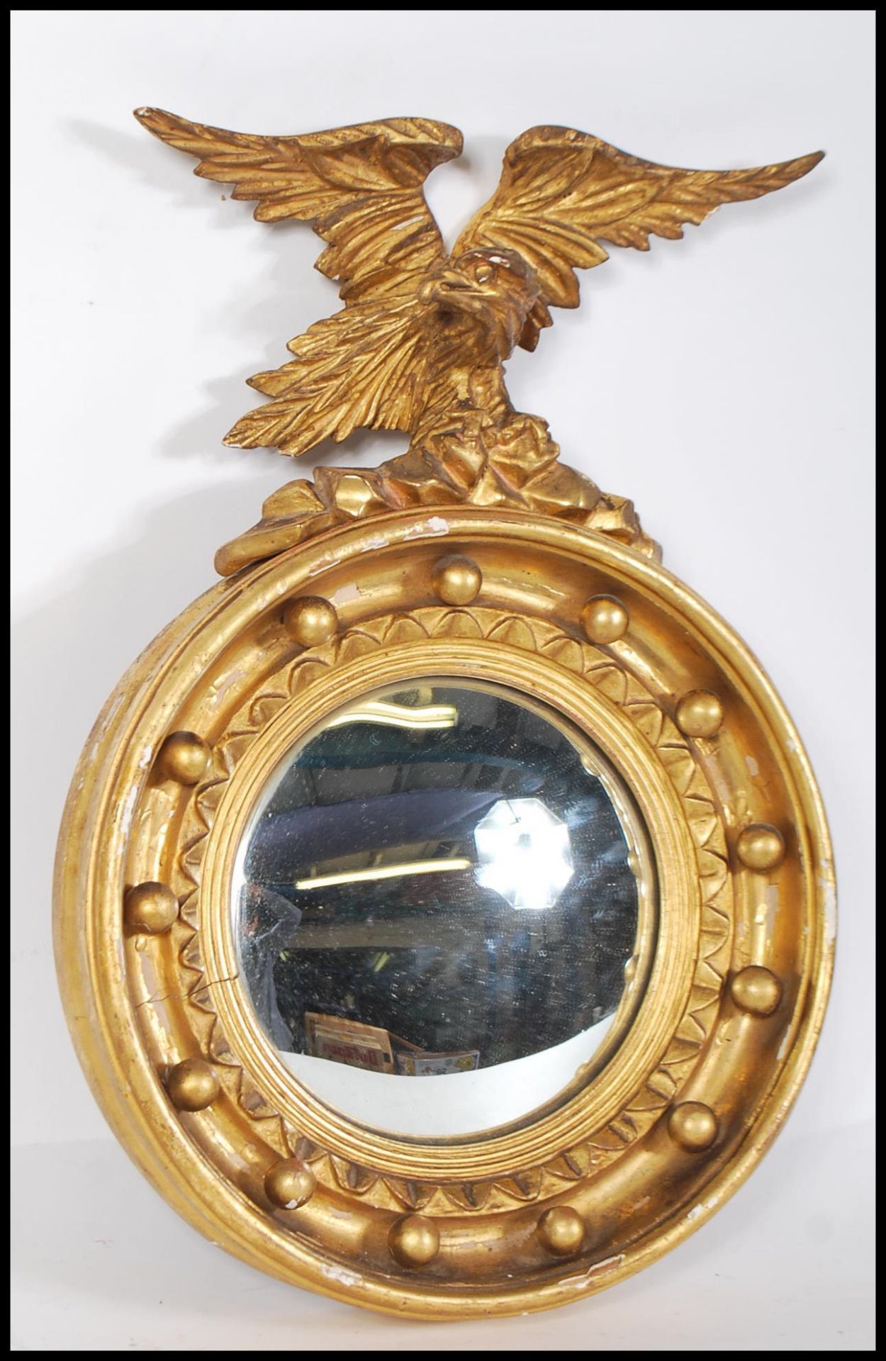 A 19th century gilt wood and gesso convex porthole mirror applied with eagle atop. The circular