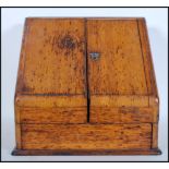 An early 20th Century light oak stationary desk tidy with double doors revealing compartmental