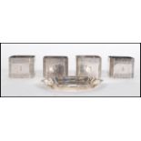 A set for Elkington silver plate napkin rings of square octagonal form having engraved foliate and