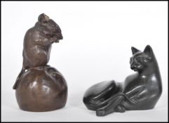 A 20th Century bronze effect figure of a mouse sitting atop of an apple nibbling on a piece of it.