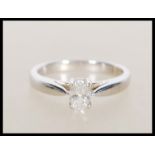 A hallmarked 750 18ct white gold oval single stone solitaire diamond ring having a central claw