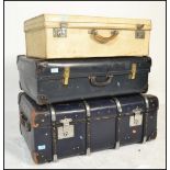 A stack of mid century vintage suitcases to include a black faux leather example with another faux