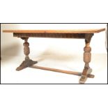 A 20th Century oak refectory dining table, the rectangular top set over a carved frieze borders