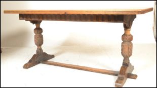A 20th Century oak refectory dining table, the rectangular top set over a carved frieze borders