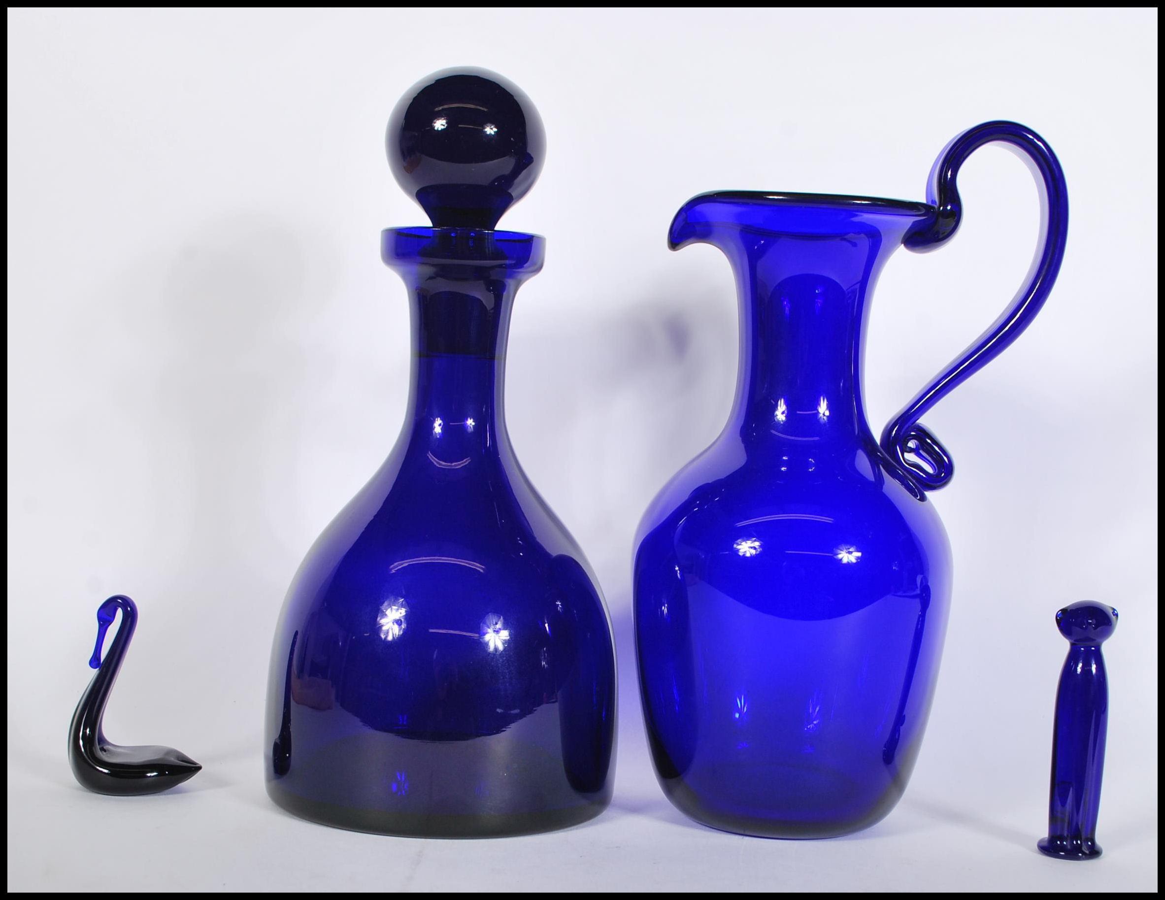 A collection of Bristol Blue studio glass to include a decanter with stopper, ewer, cat and a