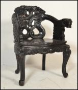 An early 20th century Chinese ebonised hardwood armchair. Raised on c-scroll feet with panel seat,