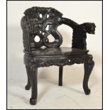 An early 20th century Chinese ebonised hardwood armchair. Raised on c-scroll feet with panel seat,