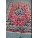 An early 20th Century Persian / Islamic large floor rug / carpet on red ground, central panel with