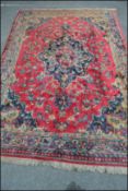 An early 20th Century Persian / Islamic large floor rug / carpet on red ground, central panel with