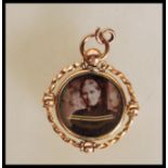 A late 19th Century / early 20th Century 9ct gold mourning pendant of round form having a central