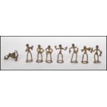 A collection of cast bronze Akan Ashanti gold weights in the form of men, some modelled playing