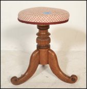 A Victorian 19th century mahogany revolving piano stool. Mid 19th century having an upholstered