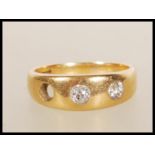 A stamped 18ct gold gypsy ring set with two round cut diamonds (the third is missing). Weight 6.