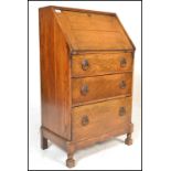 A 1920's solid oak ladies writing bureau. Of thin upright form being raised on stub cabriole legs