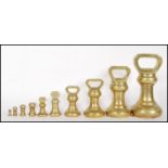 A selection of 20th century graduating brass bell weights having carrying handles atop, with the