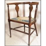 An Edwardian mahogany inlaid corner chair. Raised on turned legs with pad seat united by stretchers.