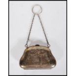 A silver hallmarked coin purse being engraved with bows and floral garlands with chain to the top,