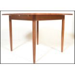 A retro teak wood 20th Century extendable dining table raised on tapering shaped supports together