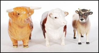 A Beswick ceramic figure modelled as a Highland Bull together with a Beswick Hereford Bull and a