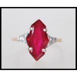 A 9ct gold ring having prong set synthetic fancy cut ruby with white gold shoulders on a lozenge