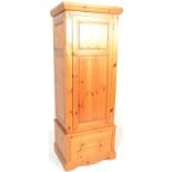 An antique style country pine sentry box wardrobe. Raised on a plinth base with short drawer