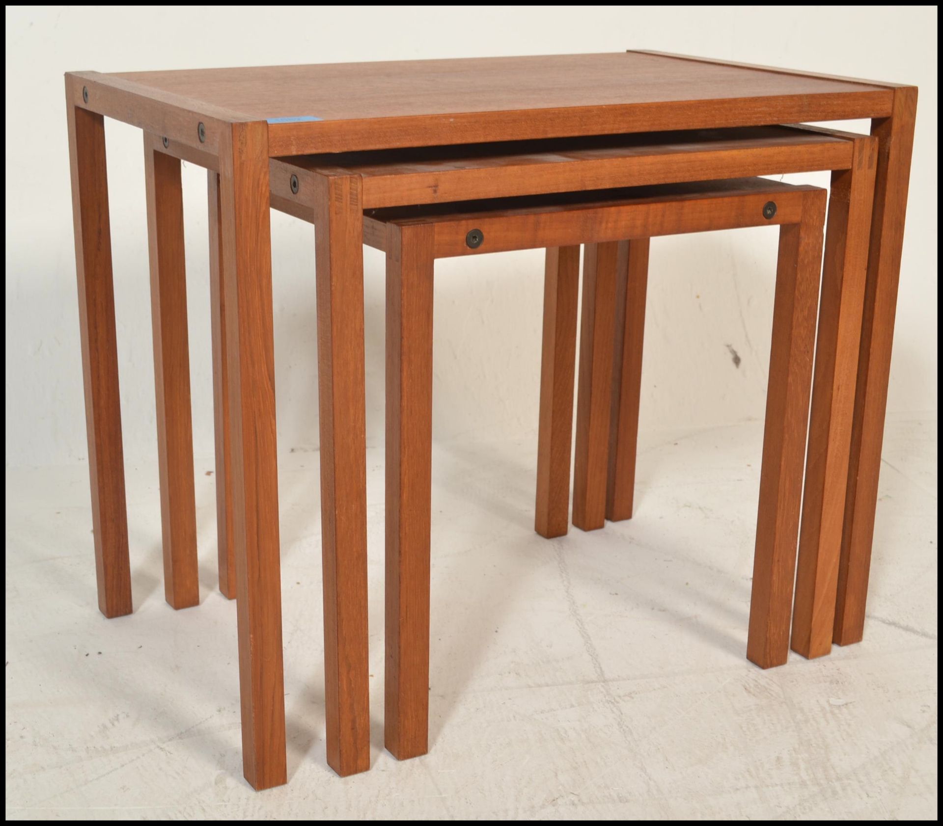 A 20th century retro vintage teak wood nest of tables of simple form with exposed finger joints to