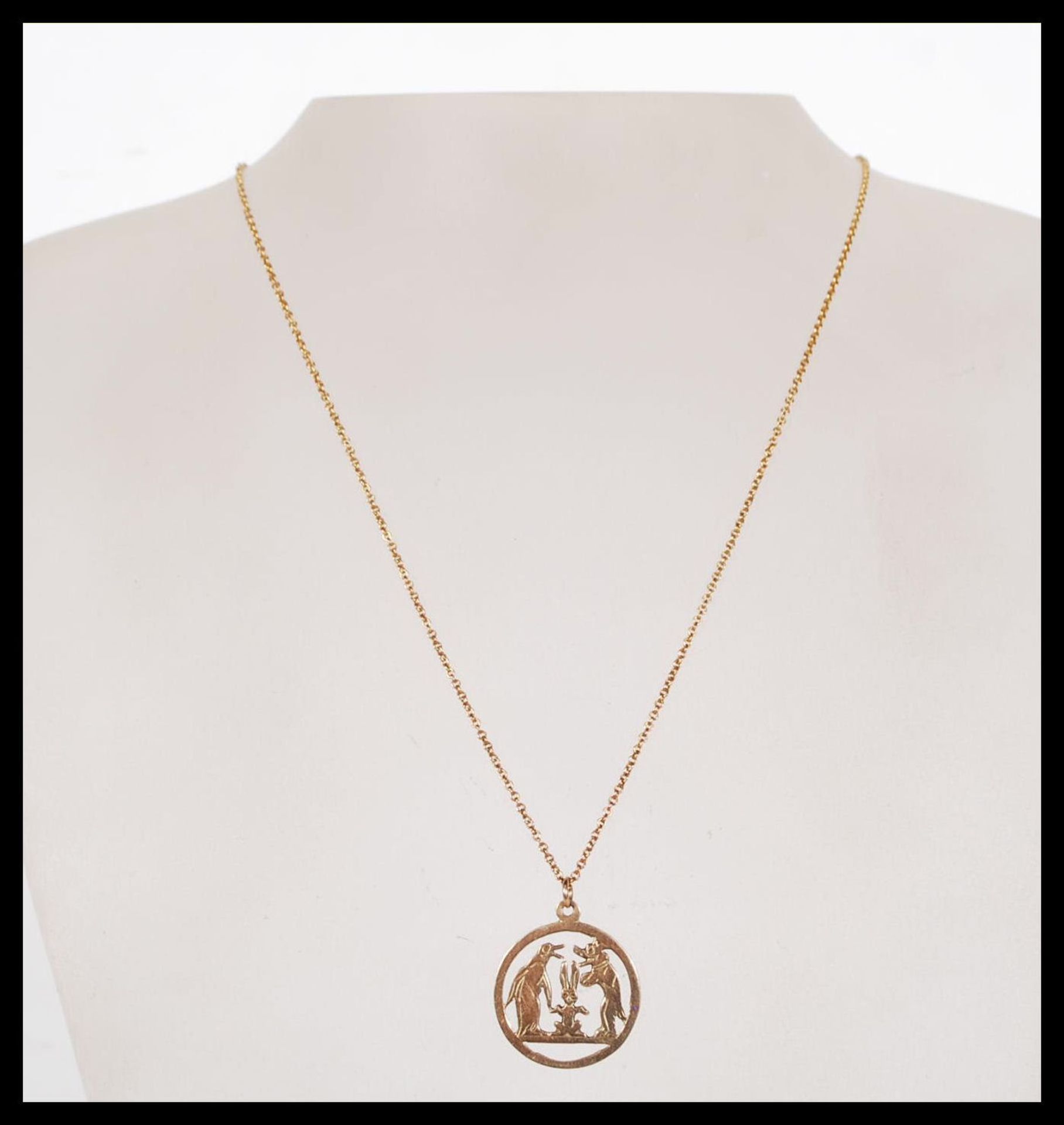 A stamped 9ct gold necklace having a round pendant having pierced decoration in the form of a dog, - Bild 2 aus 6