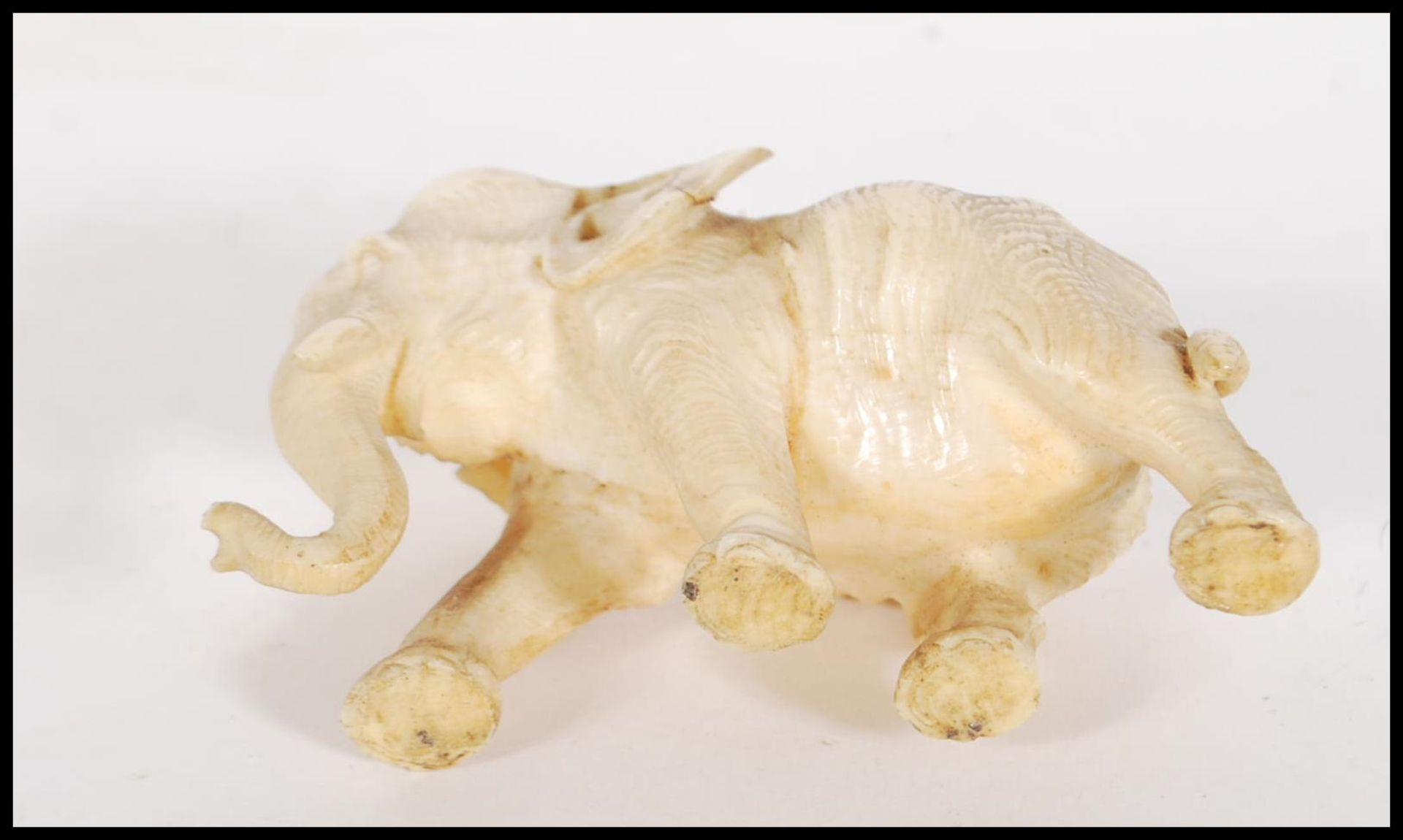 A good quality antique carved ivory figure of a elephant in a walking position. Together with a - Bild 6 aus 6