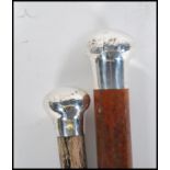 Two early 20th Century silver top walking stick canes of tapering form. One having a silver