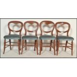 A set of 4 Victorian mahogany balloon back dining chairs raised on turned legs united by