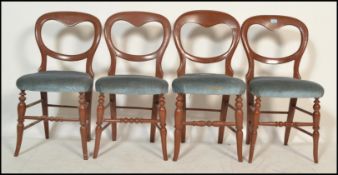 A set of 4 Victorian mahogany balloon back dining chairs raised on turned legs united by