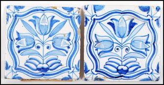 A pair of 18th Century Delft tiles hand painted in blue and white with tulip flowers within curved
