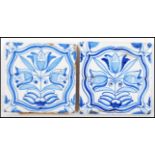 A pair of 18th Century Delft tiles hand painted in blue and white with tulip flowers within curved