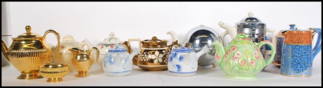 A collection of teapots dating from the early 20th Century to include an example by Clarice Cliff,