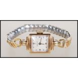 A hallmarked 9ct gold ladies cocktail wrist watch having square silvered dial marked Omega, on a