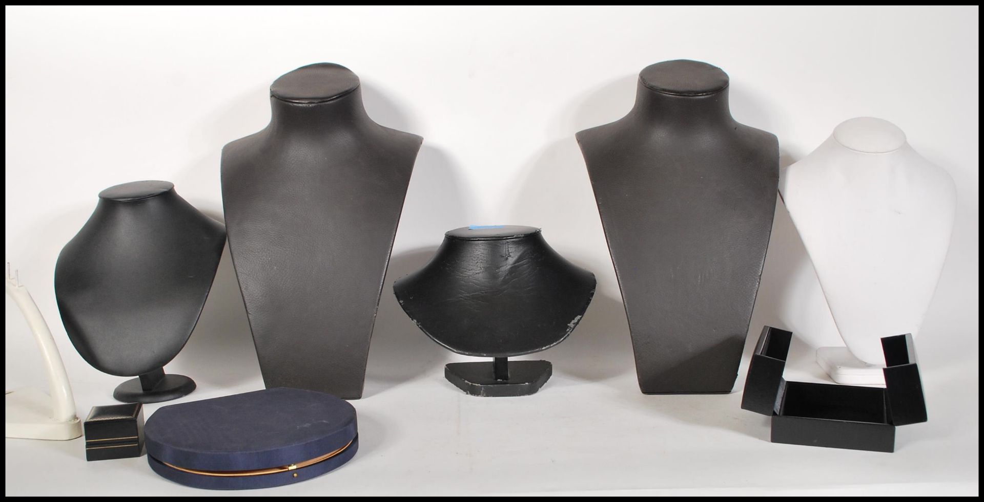 A collection of jewellery necklace counter top display stands upholstered in black and white leather