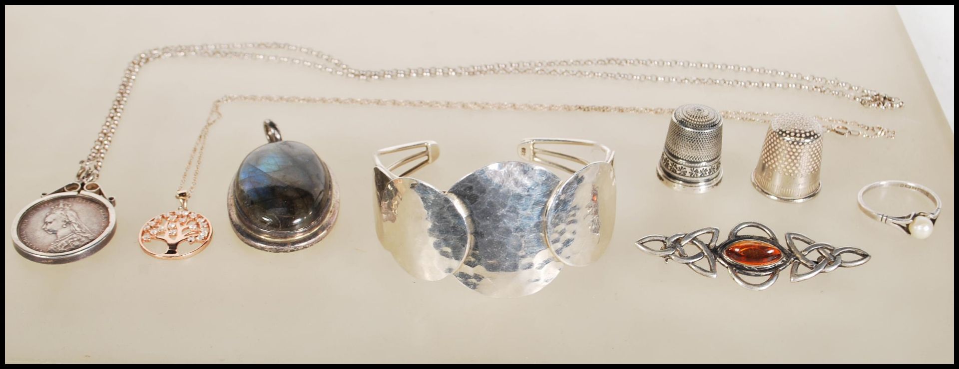 A small group of silver jewelry to include a Victorian coin in a silver mount on a chain, small tree