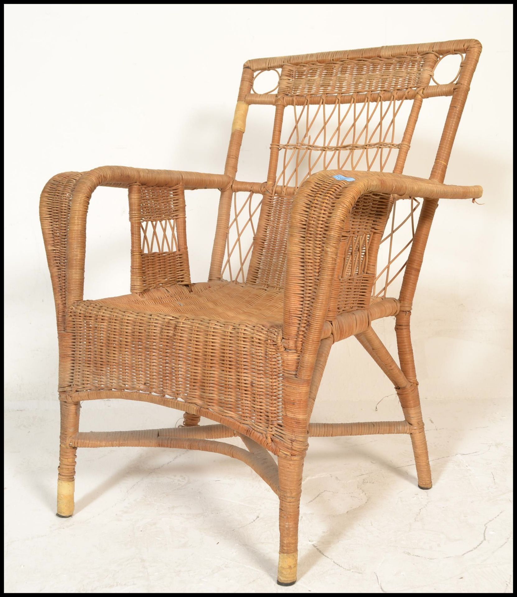 An early to mid century bamboo / whicker rattan weave plantation chair. Swept arms with a pierced