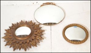 A group of three vintage 20th Century convex mirrors to include a sunburst framed mirror, a round