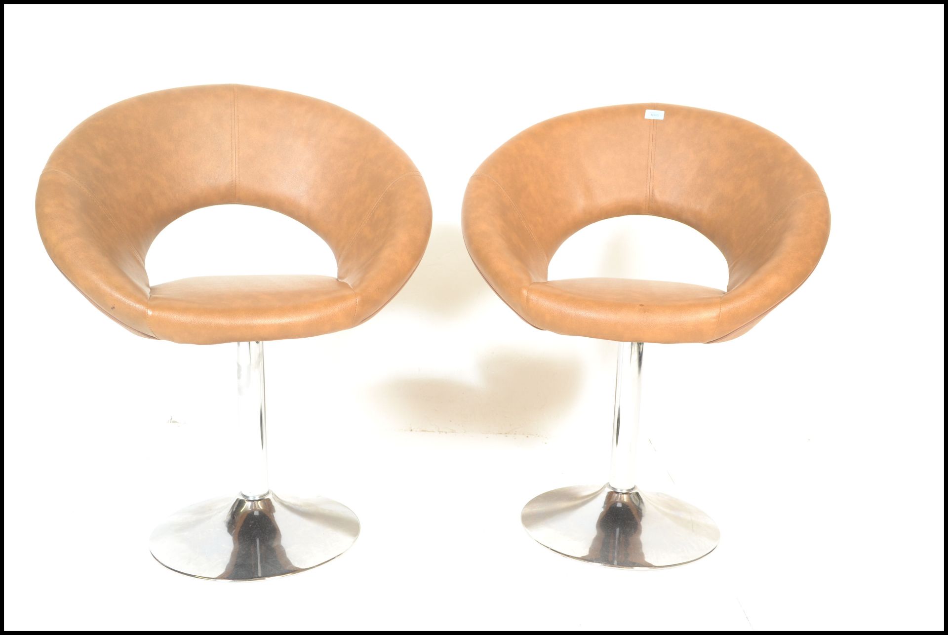 A pair of contemporary modernist satellite style swivel chairs raised on central chromed columns