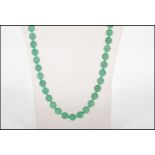 A vintage Chinese green jade or Peking glass prayer bead necklace having a set of round beads. Total